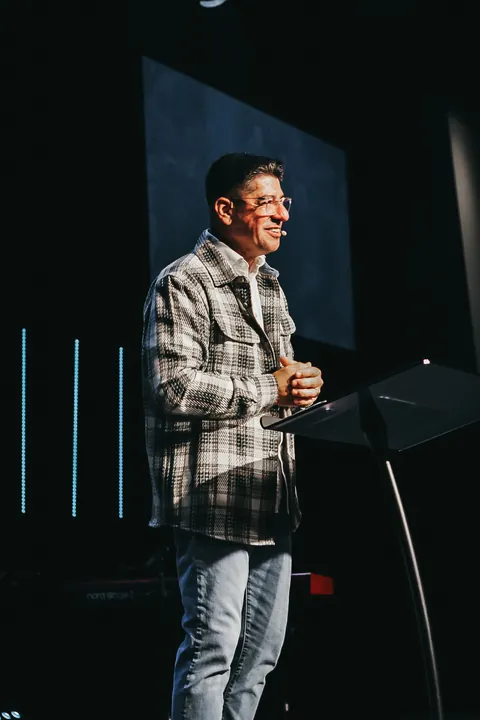 A speaker at the lectern with stage lighting and a video display at Radiant Church’s Brandon location.