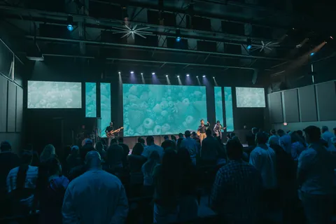 Worship team, projection screens, lighting, and congregation at Radiant Church’s Heights location.