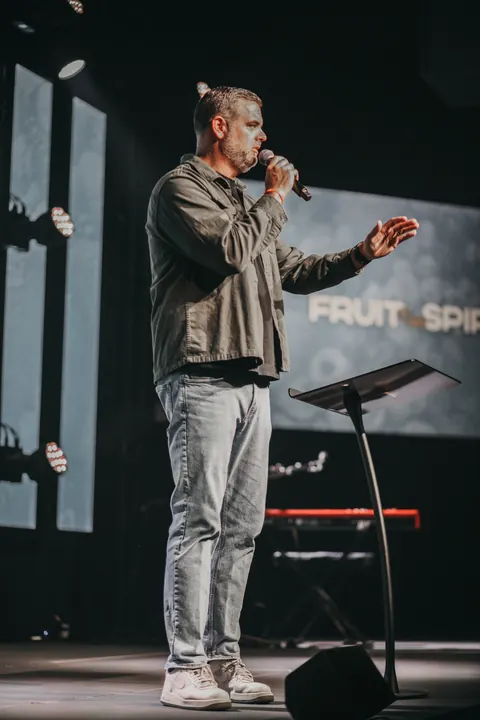 A speaker onstage with video displays and floor monitors at Radiant Church’s Hillsborough location.
