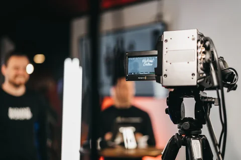 A broadcast camera on a tripod in a Radiant Church production space.